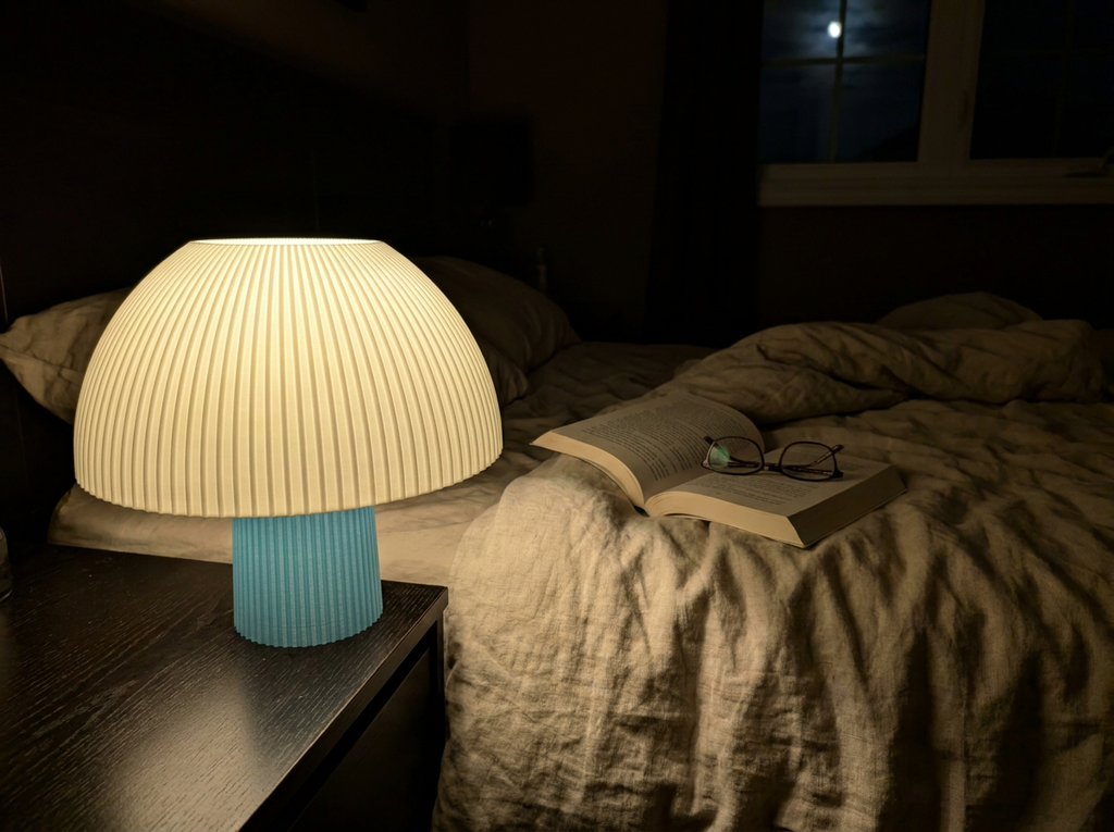Mushroom lamp glowing at night on a bedside table in a dark bedroom