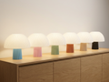 Six ribbed mushroom table lamps with white glowing shades and matte bases in sky blue, sakura pink, sage green, terracotta, latte and charcoal